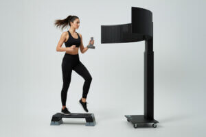 Atleta impegnata in un esercizio motorio davanti al dispositivo AvDesk per l'allenamento delle capacità neuro-visive e cognitive in ambito sportivo.