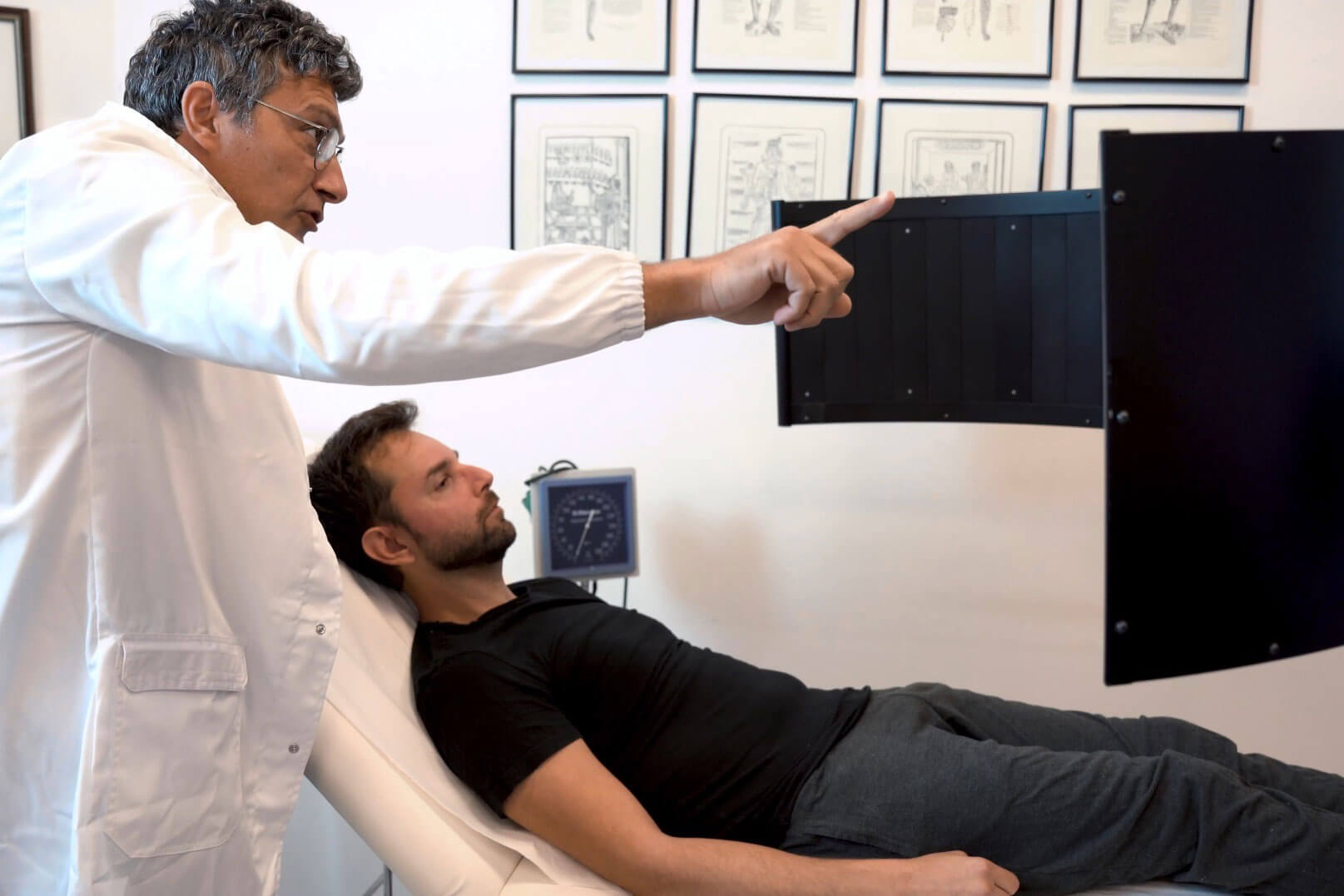 Medico che utilizza il dispositivo AvDesk per la valutazione neuro-visiva di un paziente disteso su lettino in ambulatorio specialistico.
